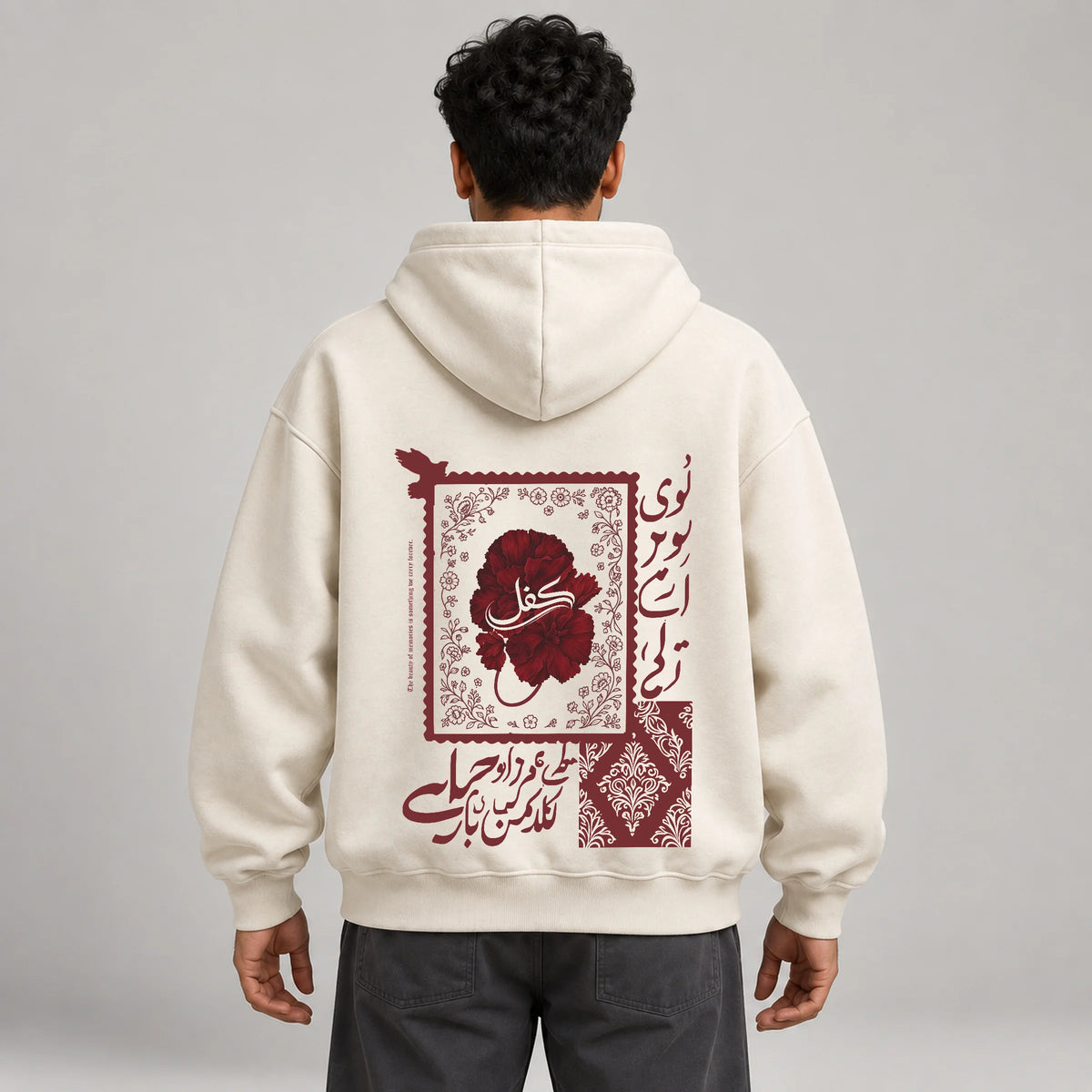 Model wearing KIFL Urdu Floral oversized hoodie in ivory – straight back view of calligraphy and floral print
